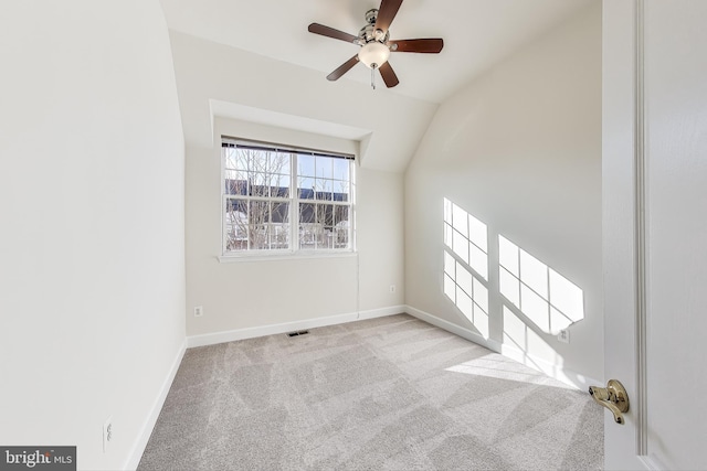 carpeted empty room featuring vaulted ceiling and ceiling fan