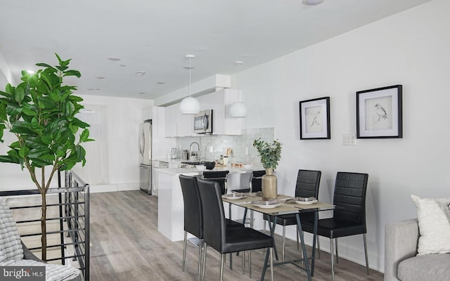 dining area with sink and light wood-type flooring