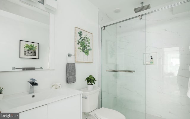 bathroom featuring vanity, toilet, and a shower with door