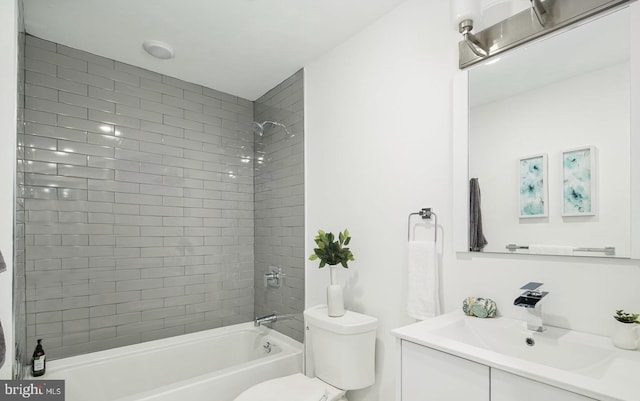 full bathroom featuring tiled shower / bath combo, toilet, and vanity