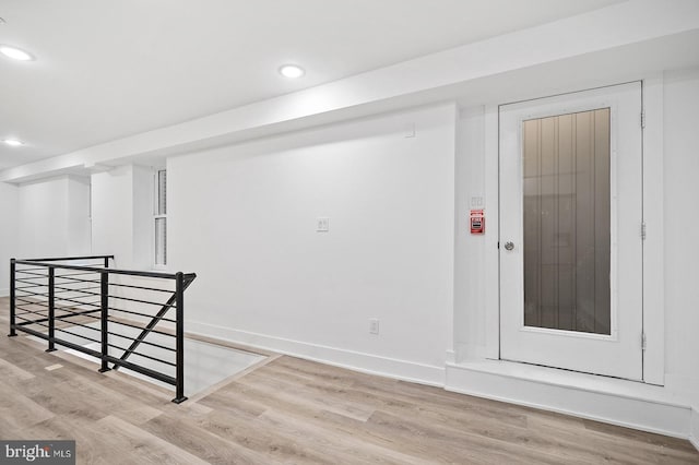 basement with light hardwood / wood-style floors