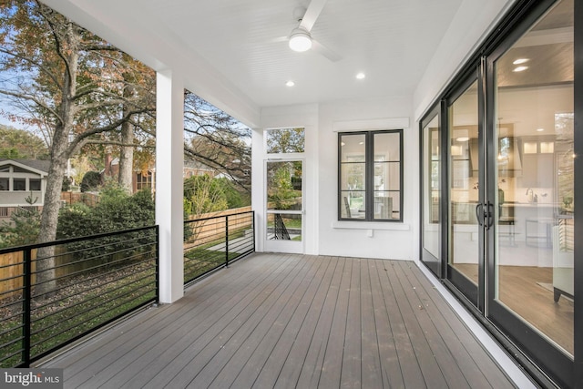 unfurnished sunroom featuring ceiling fan and a healthy amount of sunlight