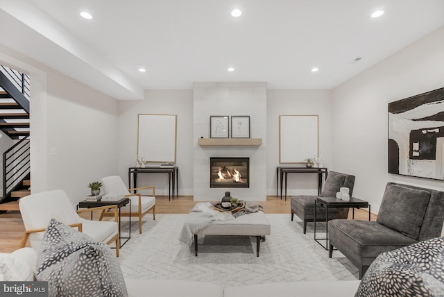 living room with a large fireplace and light hardwood / wood-style floors