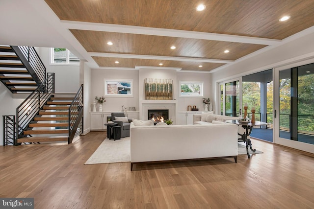 living room featuring beam ceiling, light wood-type flooring, and wooden ceiling