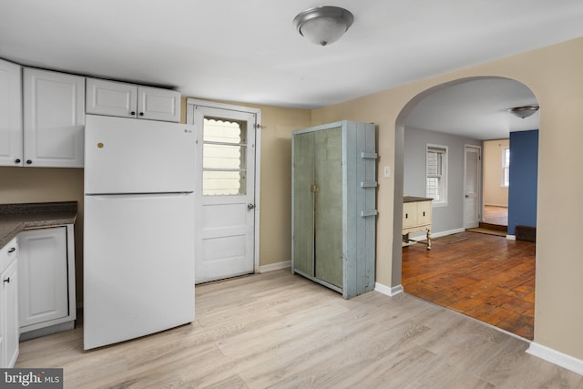 kitchen featuring white fridge, white cabinetry, and light hardwood / wood-style flooring