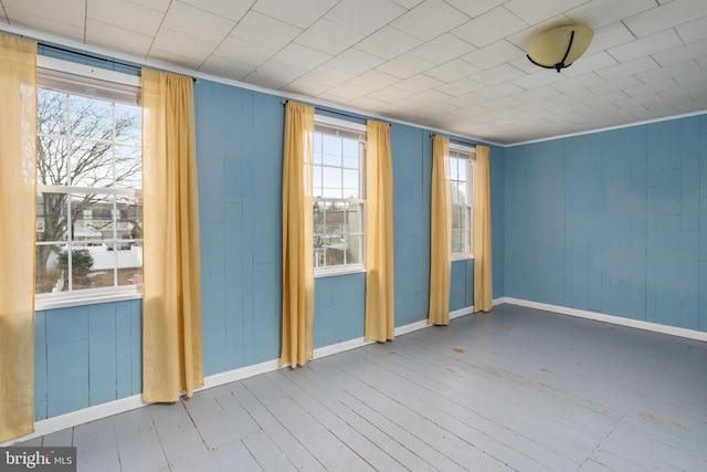 spare room with hardwood / wood-style flooring and crown molding