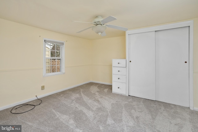 unfurnished bedroom with light carpet, a closet, and ceiling fan