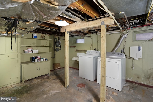 basement featuring independent washer and dryer and sink