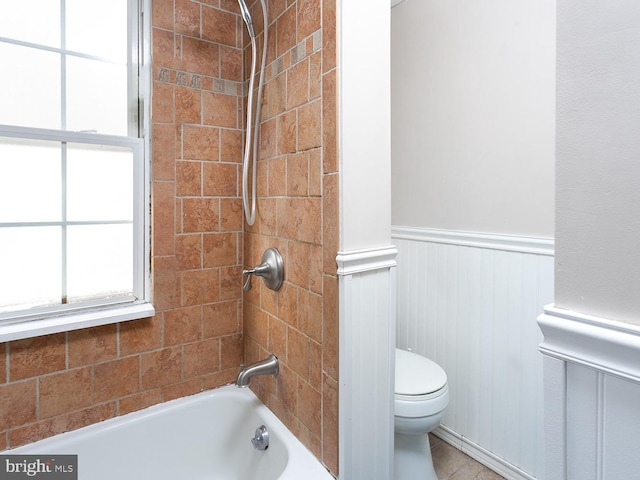 bathroom with tiled shower / bath combo and toilet