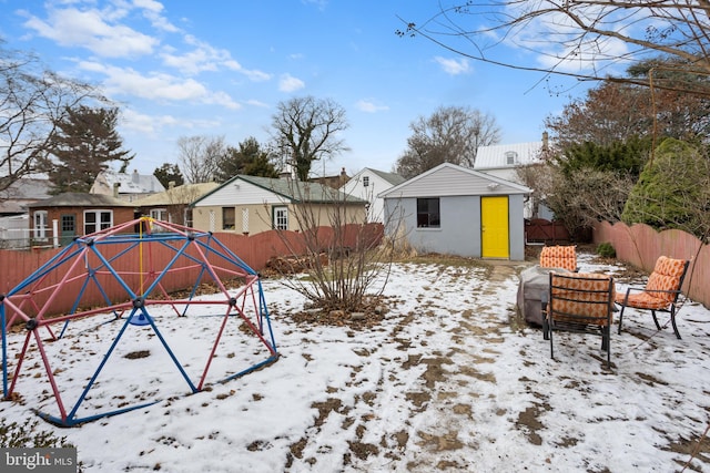 snowy yard with an outbuilding and a playground