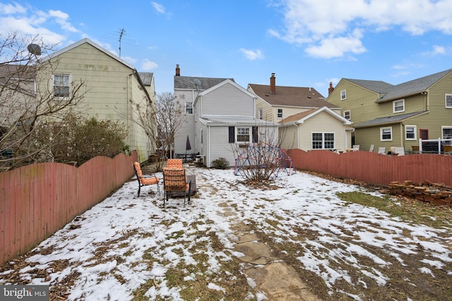 view of snow covered rear of property