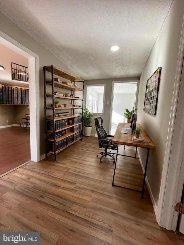 office area featuring hardwood / wood-style floors, a textured ceiling, and lofted ceiling