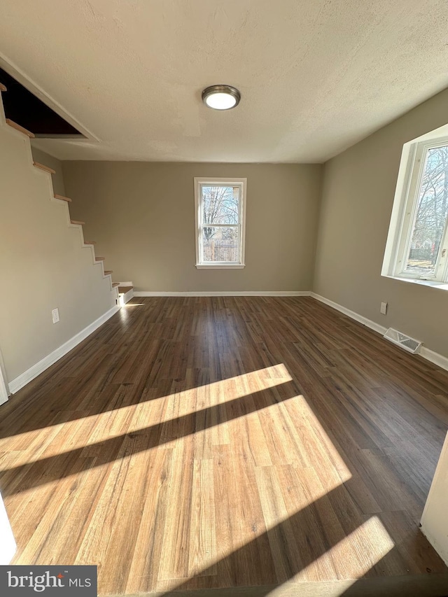 spare room with a textured ceiling and dark wood-type flooring