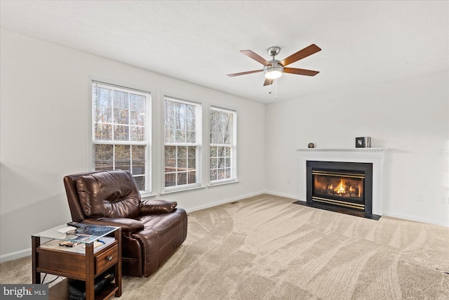 sitting room with ceiling fan and light colored carpet