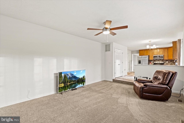 living room with carpet and ceiling fan with notable chandelier