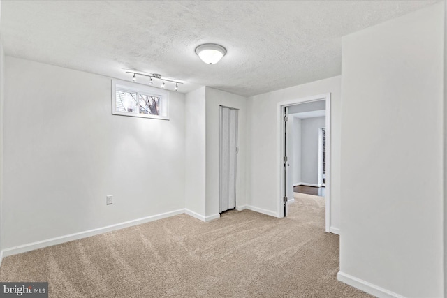 carpeted empty room with a textured ceiling