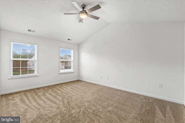 spare room featuring carpet floors, vaulted ceiling, and ceiling fan