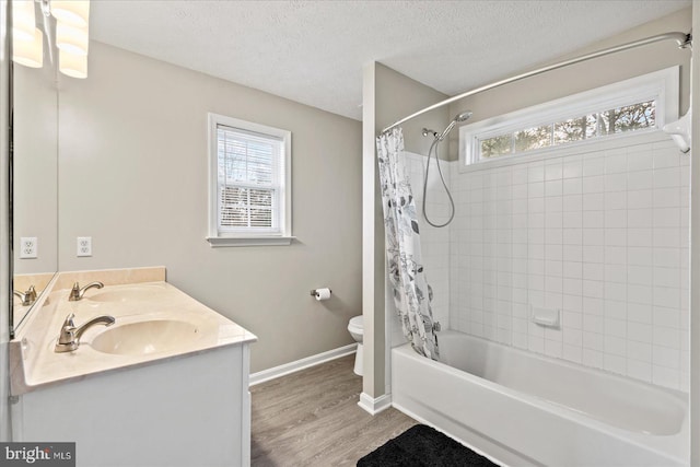 full bathroom featuring a textured ceiling, toilet, shower / tub combo with curtain, vanity, and hardwood / wood-style flooring