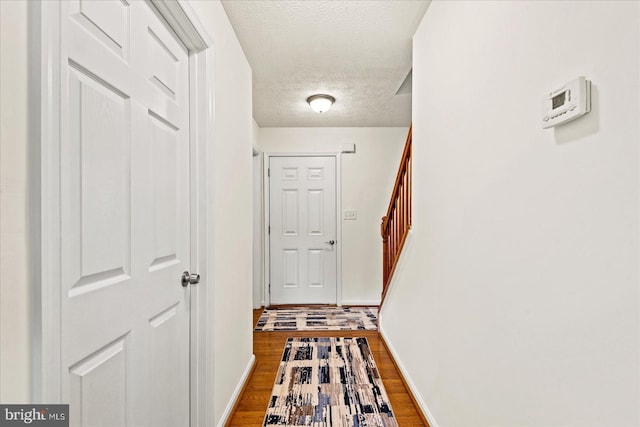 hallway featuring a textured ceiling and hardwood / wood-style flooring