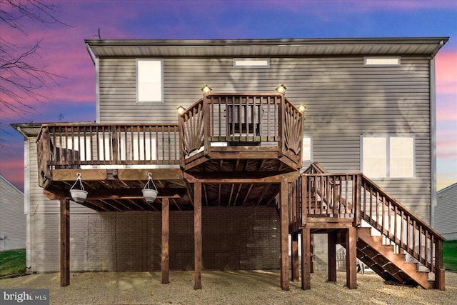 back house at dusk featuring a deck