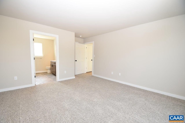 unfurnished bedroom featuring connected bathroom and light colored carpet