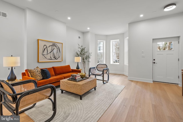 living room with light wood-type flooring, baseboards, and recessed lighting