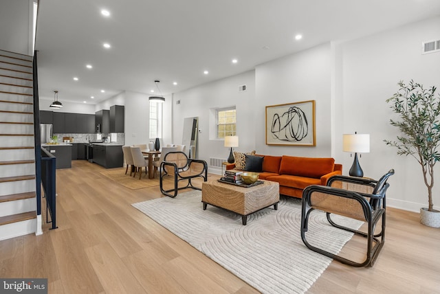 living area with stairs, light wood-type flooring, visible vents, and recessed lighting