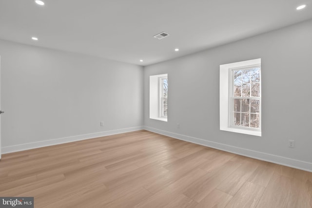 empty room with light wood-style flooring, visible vents, and recessed lighting