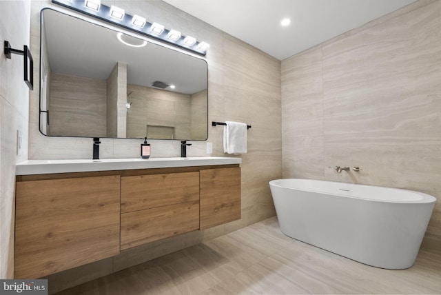 full bath featuring double vanity, tile walls, a soaking tub, a tile shower, and a sink