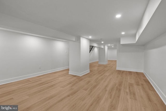 finished basement with baseboards, stairway, light wood-type flooring, and recessed lighting