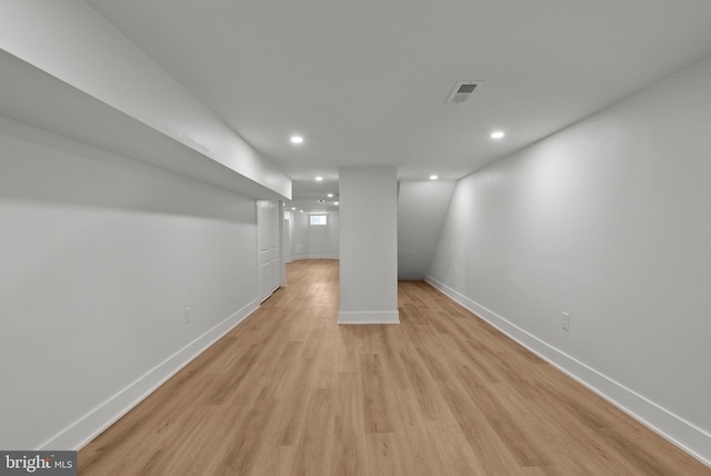 basement with light wood-style floors, recessed lighting, visible vents, and baseboards