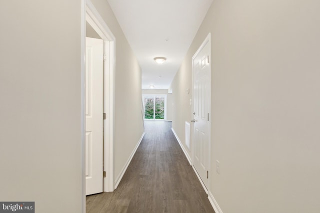 corridor with dark hardwood / wood-style flooring