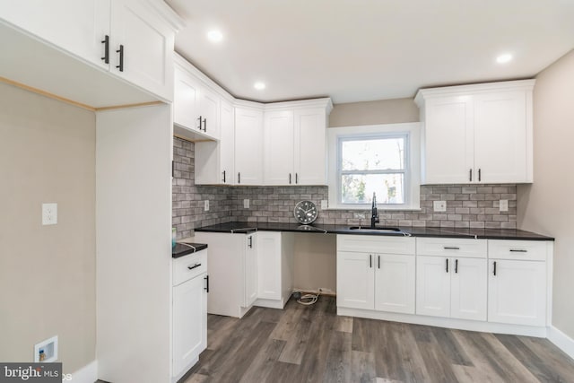 kitchen with dark hardwood / wood-style floors, white cabinetry, sink, and tasteful backsplash