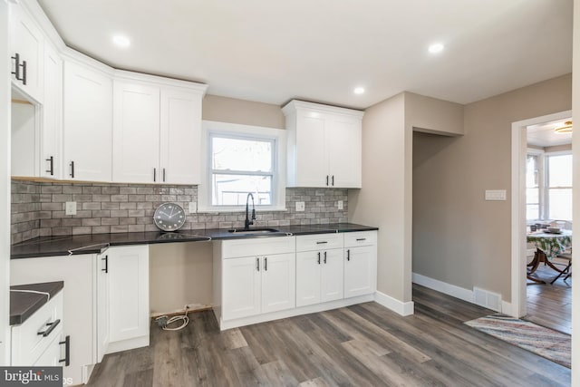 kitchen with tasteful backsplash, sink, white cabinets, and dark hardwood / wood-style floors