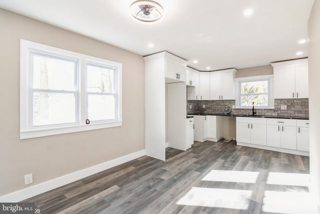 kitchen featuring white cabinets, decorative backsplash, sink, and hardwood / wood-style floors