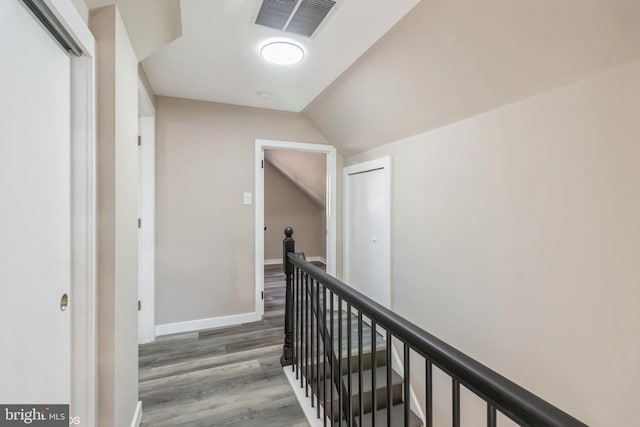 hall featuring wood-type flooring and lofted ceiling