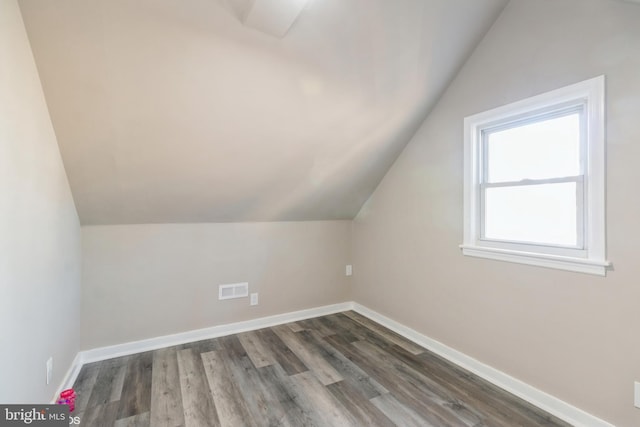 bonus room featuring dark wood-type flooring and vaulted ceiling