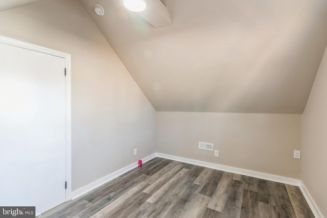 additional living space featuring dark hardwood / wood-style flooring and lofted ceiling