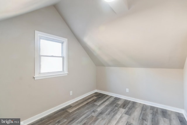 bonus room with hardwood / wood-style flooring and vaulted ceiling