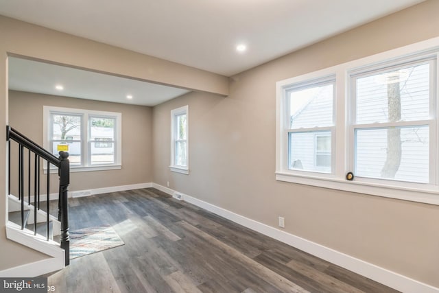 interior space with a wealth of natural light and dark hardwood / wood-style flooring