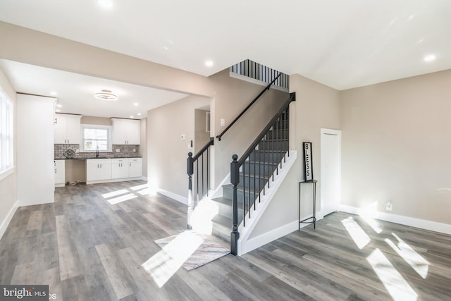 stairway with hardwood / wood-style flooring and sink