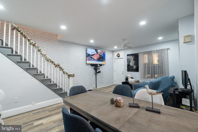 dining area featuring light hardwood / wood-style floors and brick wall