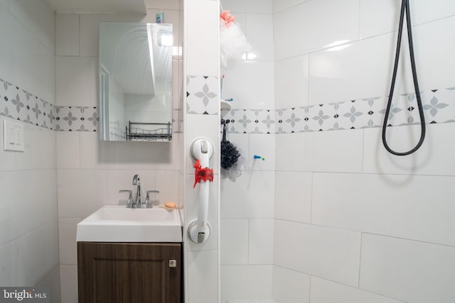 bathroom with tasteful backsplash, vanity, and tile walls