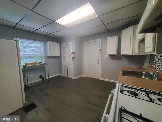 kitchen featuring dark hardwood / wood-style flooring, white cabinetry, sink, and white appliances