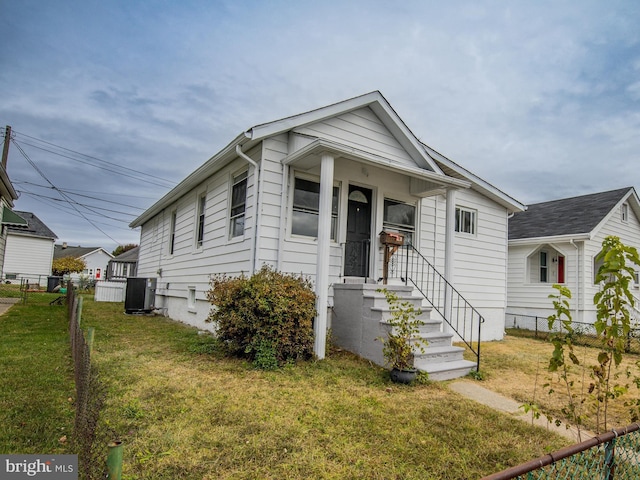 bungalow-style home featuring a front yard and central AC