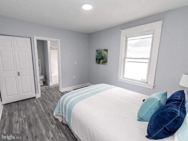 bedroom featuring ensuite bathroom, dark hardwood / wood-style flooring, and a closet