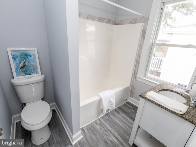 full bathroom with plenty of natural light, hardwood / wood-style floors, vanity, and  shower combination