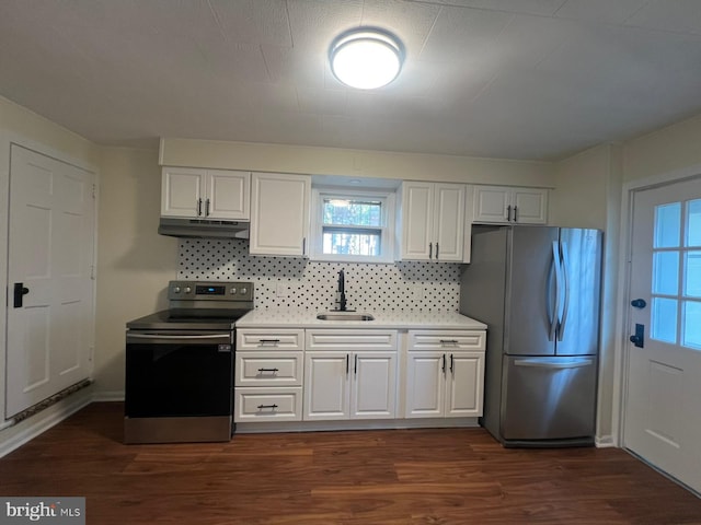 kitchen featuring appliances with stainless steel finishes, tasteful backsplash, dark wood-type flooring, sink, and white cabinetry