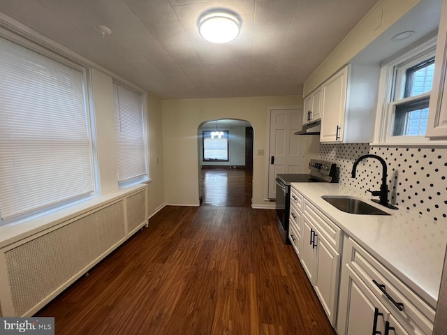 kitchen with radiator, white cabinetry, stainless steel electric stove, and sink