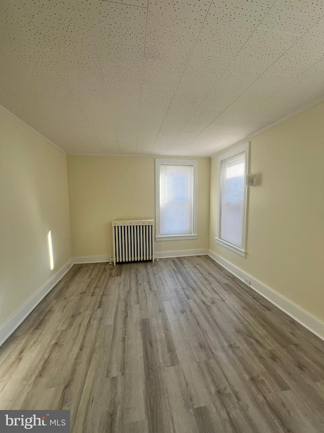 empty room with hardwood / wood-style flooring and radiator